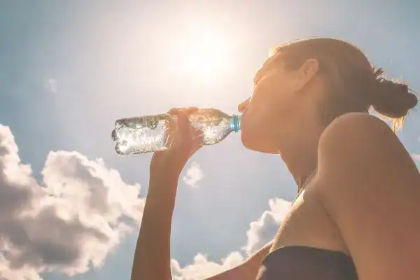 Hydration: The Secret Ingredient for a Toned Stomach and Enhanced Fitness 3 Image of woman drinking water to hydrate Hatfield after run.