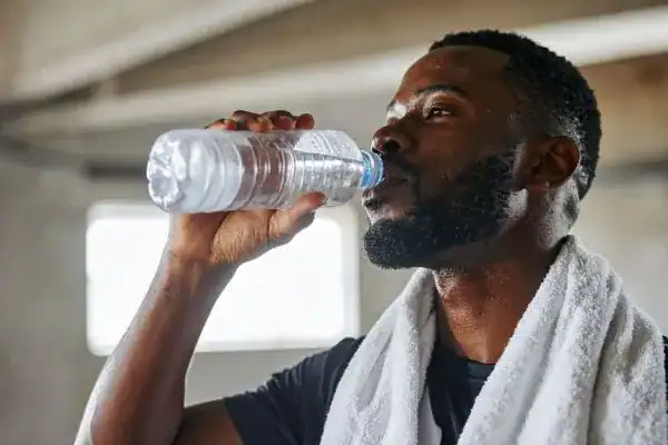 Image of man drinking water to improve hydration Hatfield after work out.